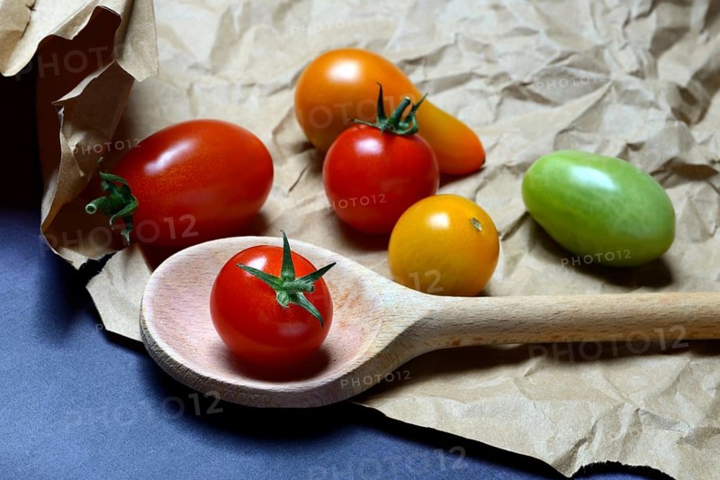 Cherry tomatoes with cooking spoon