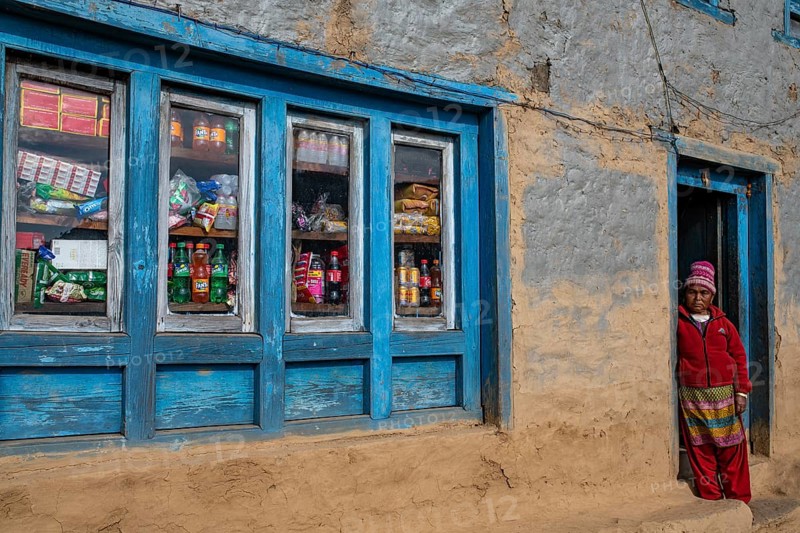A local woman standing in the doorway of her shop