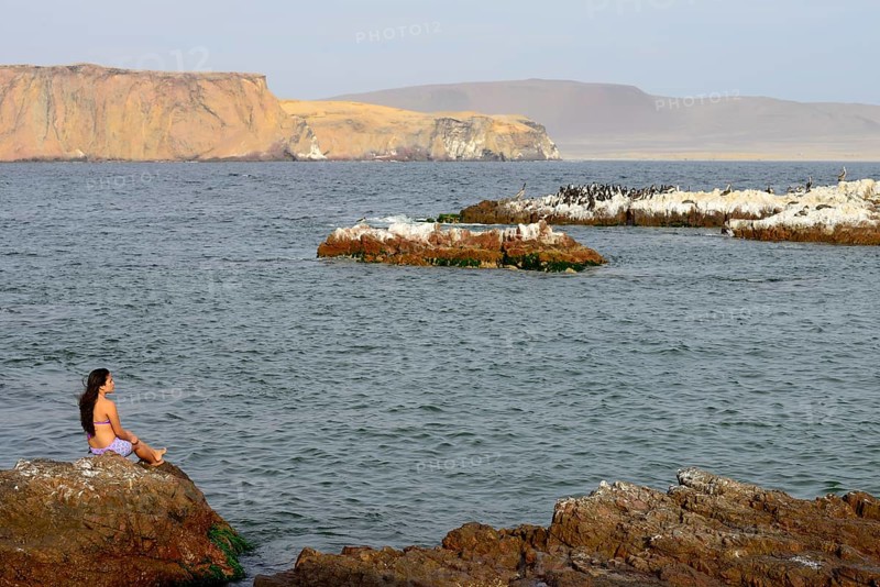 Woman sitting on a rock in Paracas National Reserve