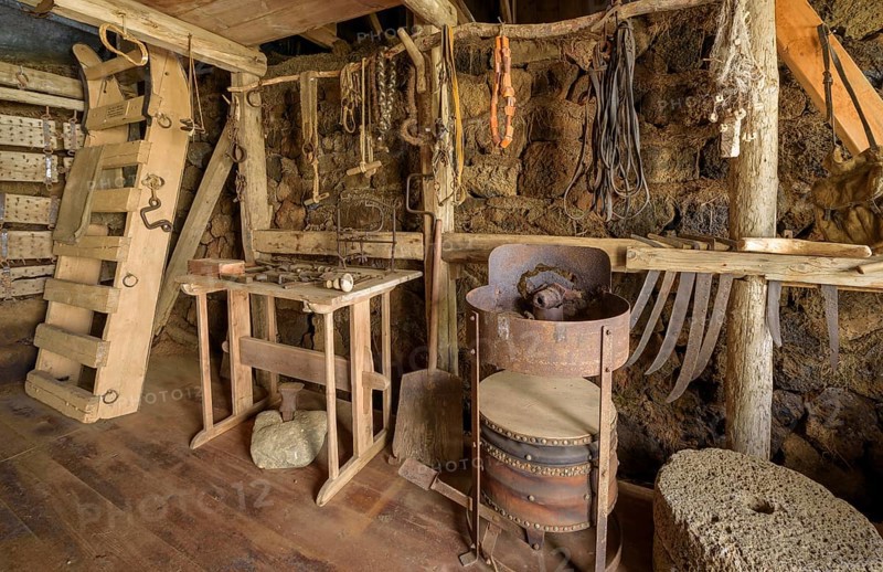 Interior view of a historical workshop with grindstone on a peat farm