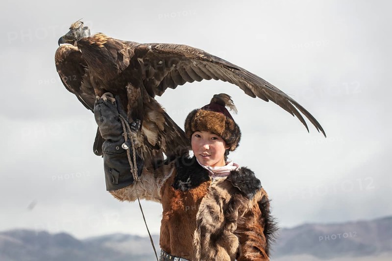 Young eagle hunter with her female eagle
