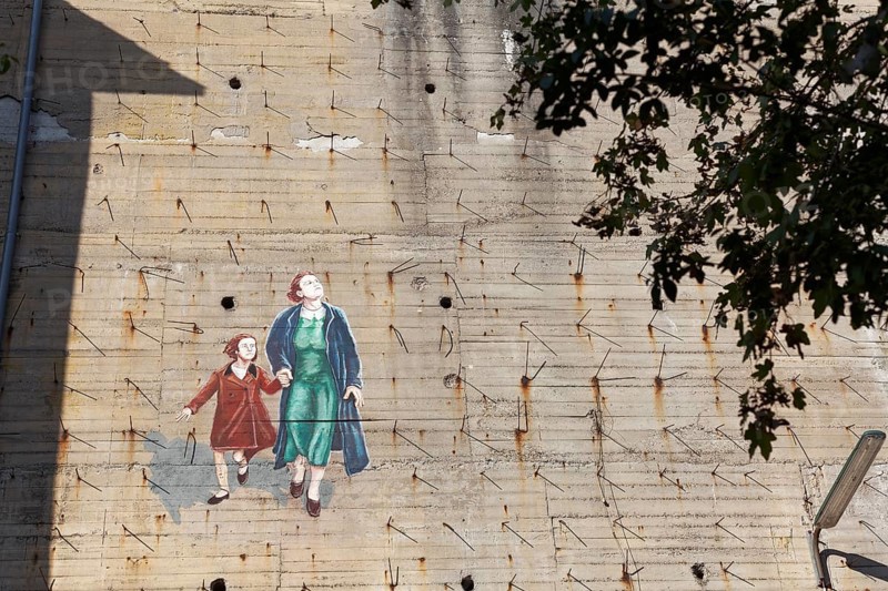 Woman with child fleeing from a bomb alarm