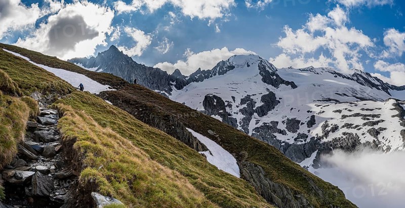 Hiking trail in front of snow-covered mountain peaks