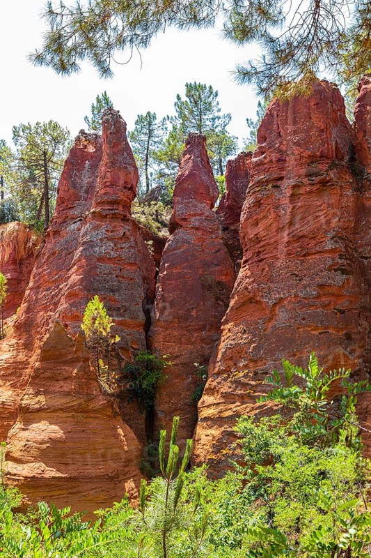 Red pyramid-shaped rocks in the natural park of ochre rocks in Roussillon