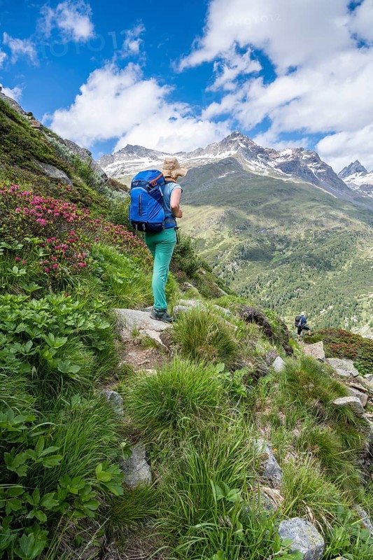 Hiker on hiking trail in front of mountains