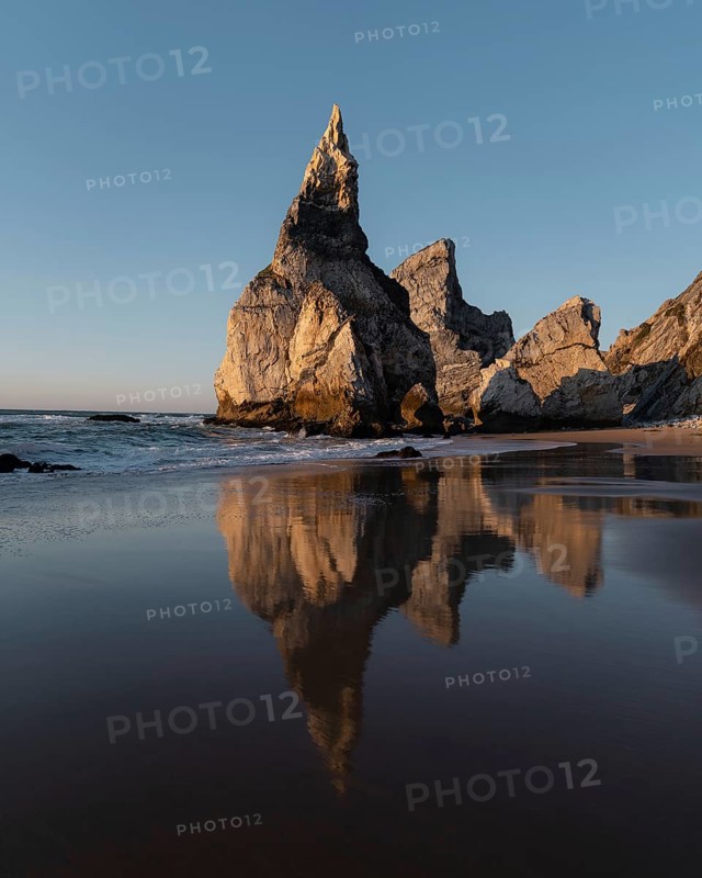 Marked rocks at Praia da Ursa beach with reflection