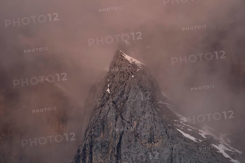 Rock face framed by clouds at sunset