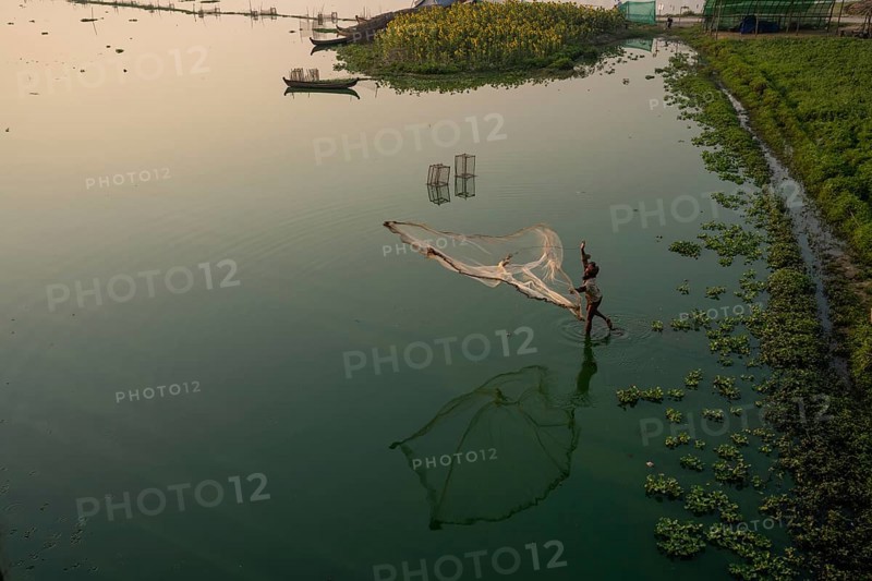 Fishermen on Taung Tha Man Lake throw out a fishing net for sunrise