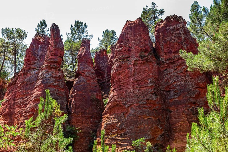 Red pyramid-shaped rocks in the natural park of ochre rocks in Roussillon