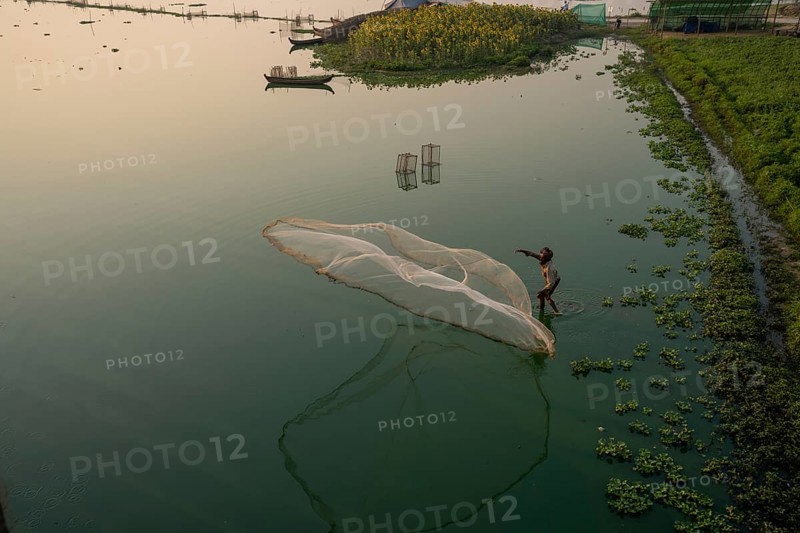Fishermen on Taung Tha Man Lake throw out a fishing net for sunrise