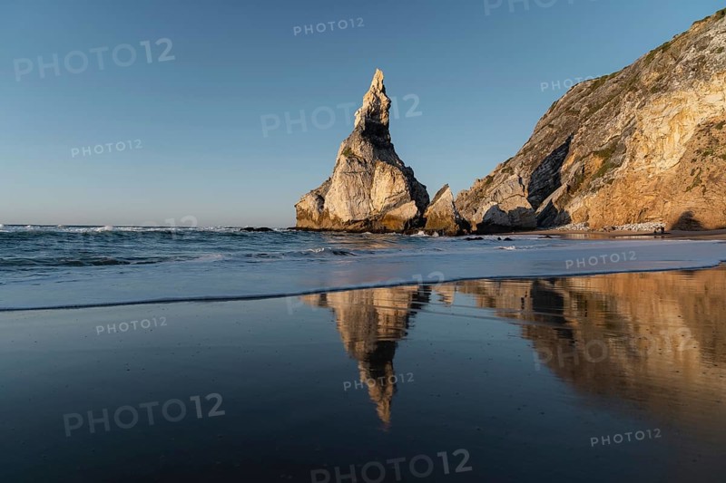 Marked rocks at Praia da Ursa beach with reflection