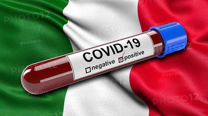 Flag of Italy waving in the wind with a positive Covid-19 blood test tube. 3D illustration