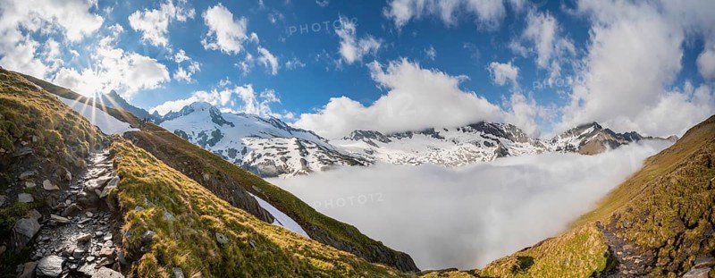 Hiking trail in front of snow-covered mountain peaks