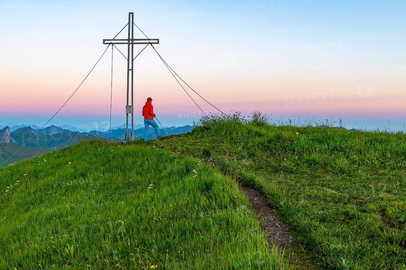 Small mountain trail with mountaineer and summit of the Uentschenspitze at sunrise