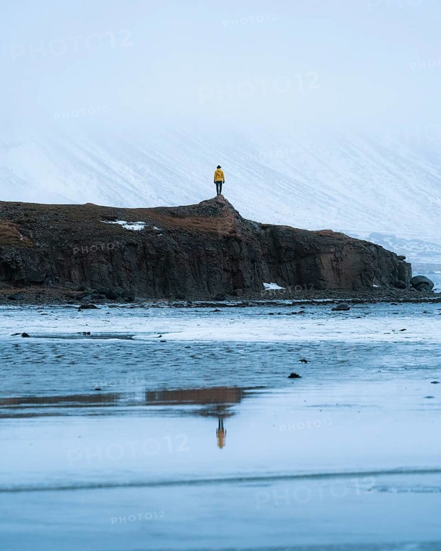 Person on a rock with reflection in water