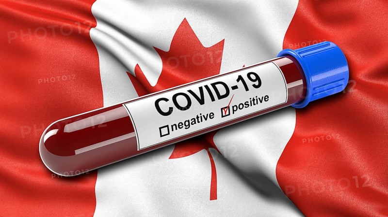 Flag of Canada waving in the wind with a positive Covid-19 blood test tube. 3D illustration