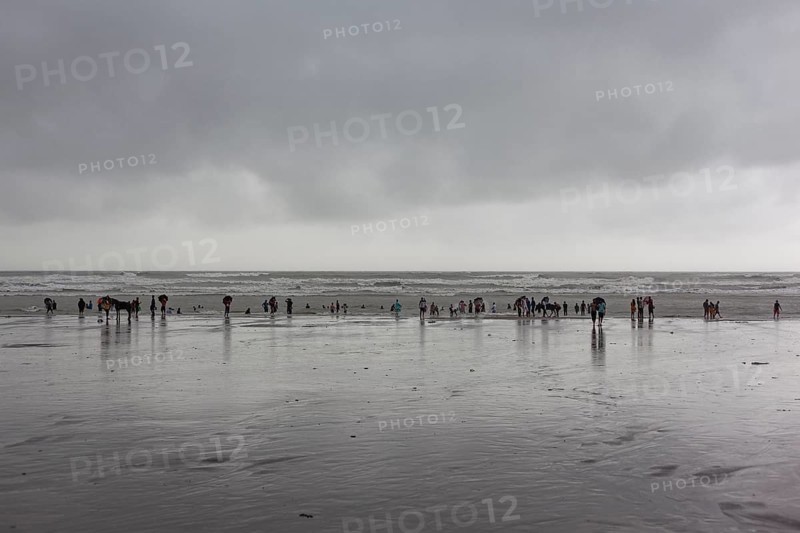 Bathers on the beach from Cox's Bazaar to monsoon rain