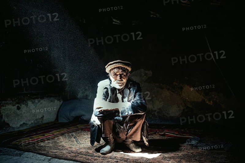 Man sitting on a carpet in his house