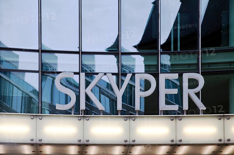 Skyper lettering in front of glass facade