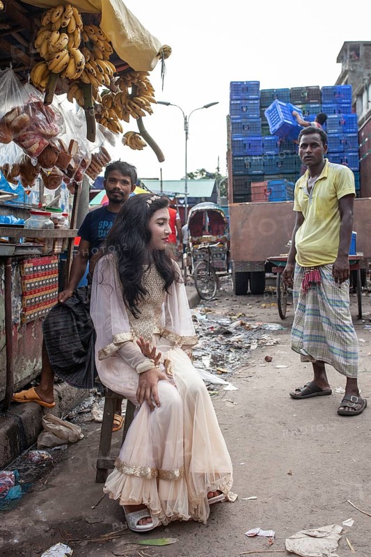 Bride sitting in front of a market stall
