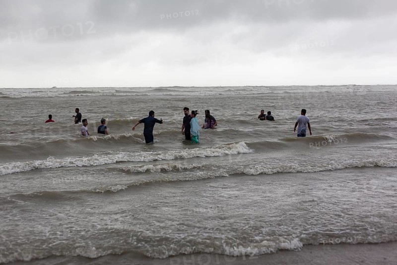 Bathers on the beach from Cox's Bazaar to monsoon rain