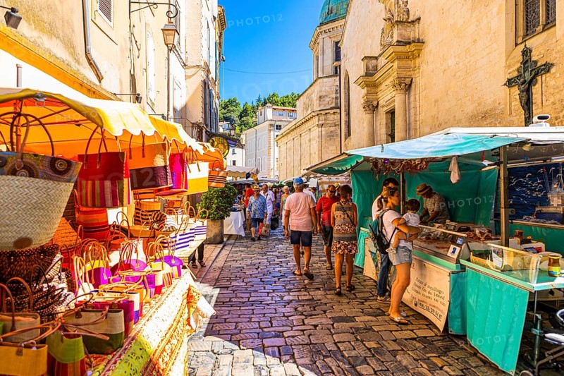 Tourists strolling through the stalls at the weekly market market in Apt