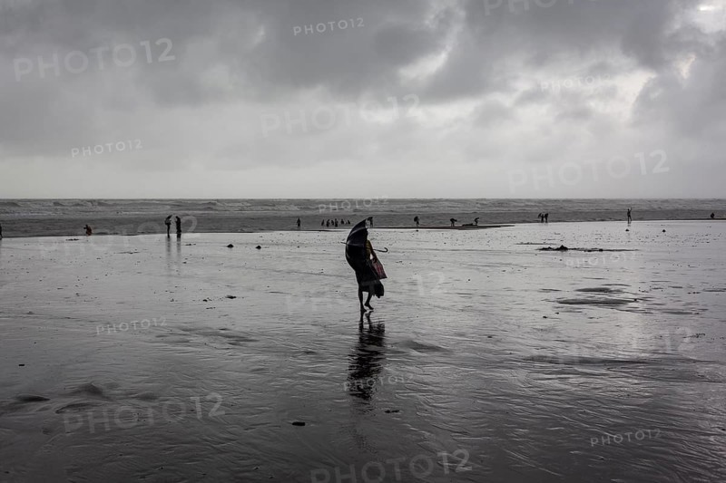 Bathers on the beach from Cox's Bazaar to monsoon rain