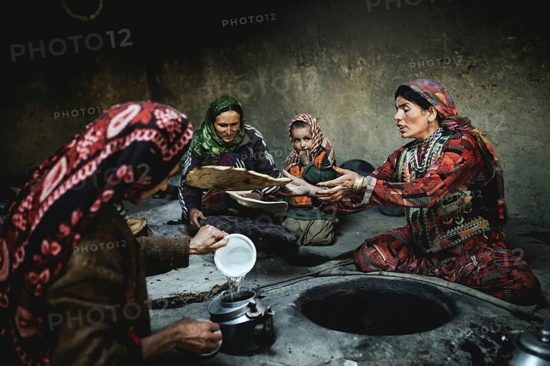 Three woman and a child baking flat bread