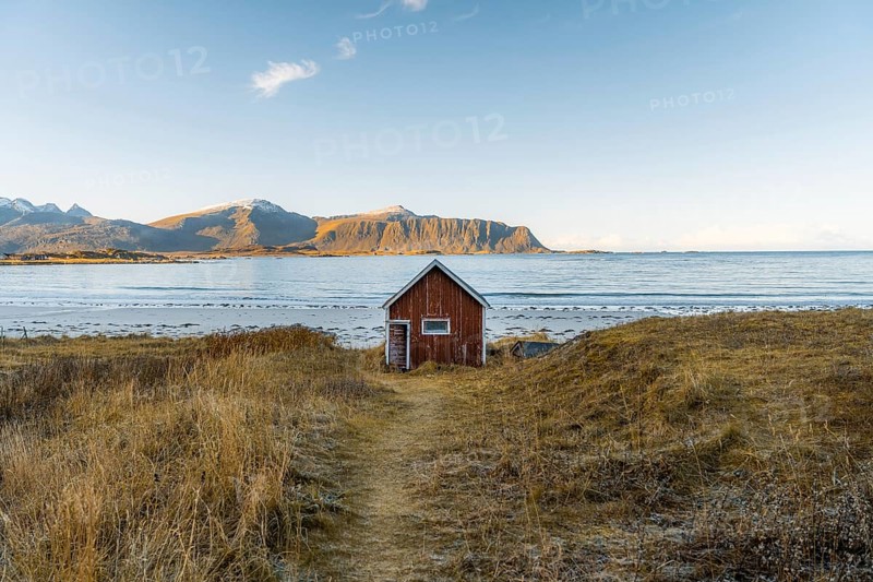 Red cabin in front of Ramberg beach at sunset