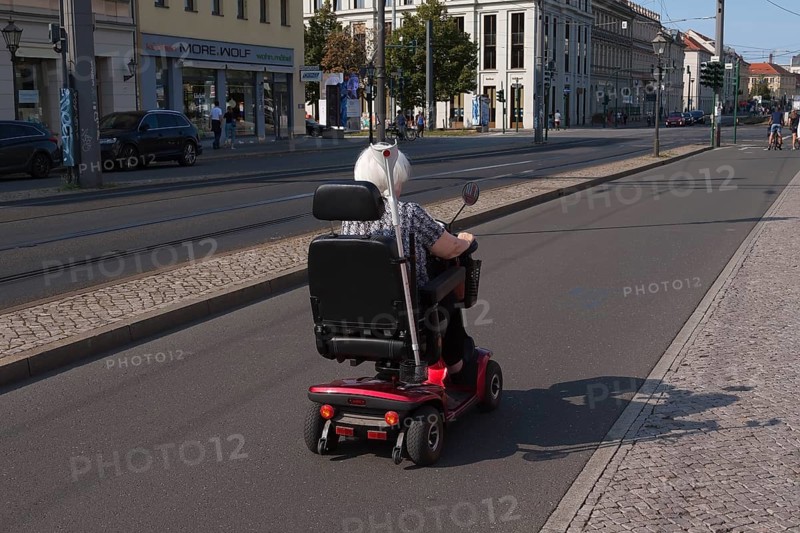Older lady in a wheelchair on a bicycle path