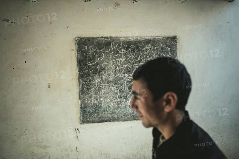 Youth in front of a blackboard in a classroom