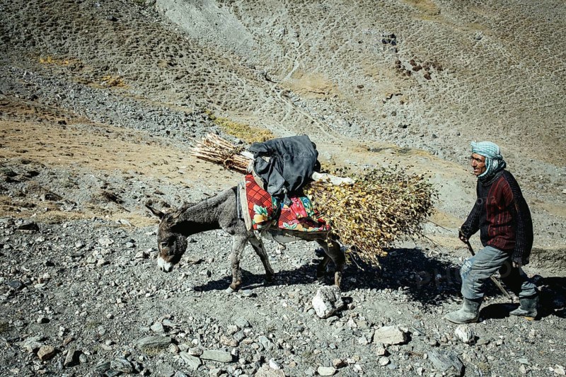 Man walking through barren mountain landscape