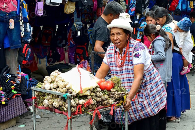 Woman pushing a trolley with garlic at the market
