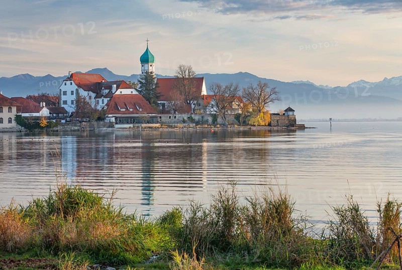 Peninsula with the parish church of St. George in front of the Alps in the evening sun