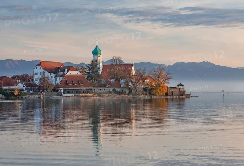 Peninsula with the parish church of St. George in front of the Alps in the evening sun