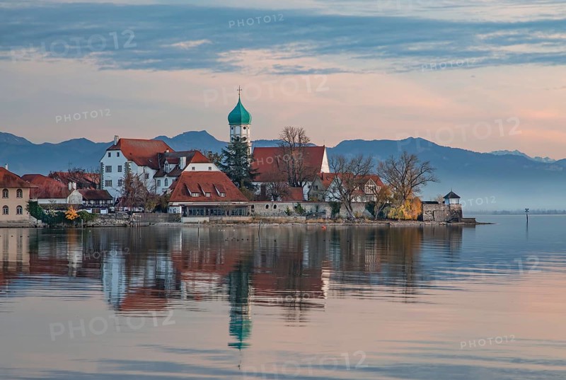 Peninsula with the parish church of St. George in front of the Alps in the evening sun