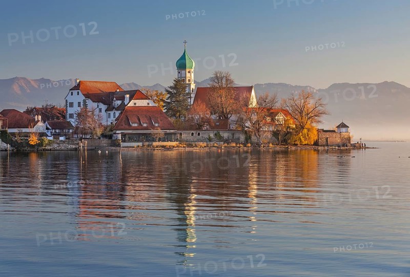 Peninsula with the parish church of St. George in front of the Alps in the evening sun