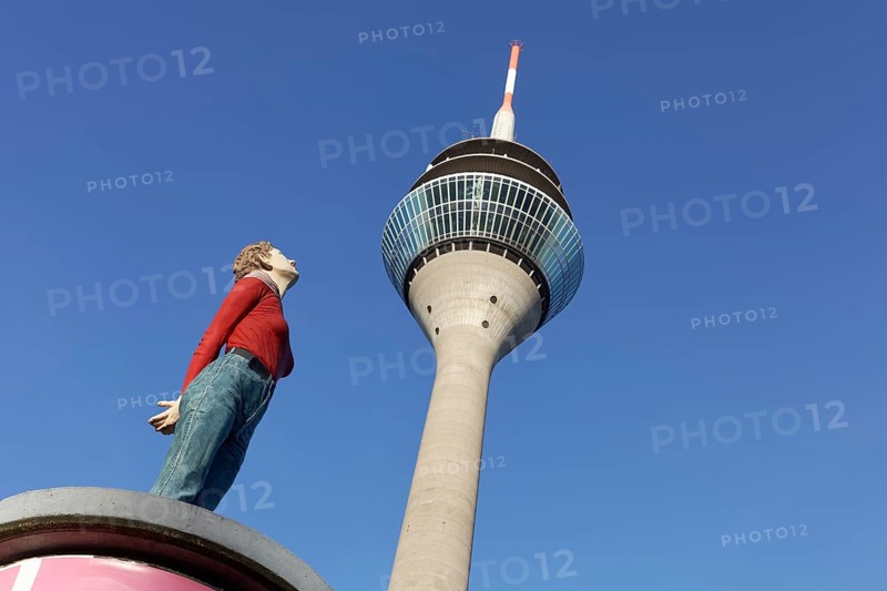 Realistic female figure on an advertising pillar in front of the Rhine Tower