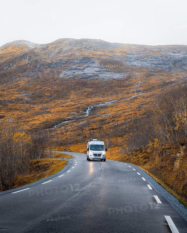 Campervan on a road with autumnal vegetation