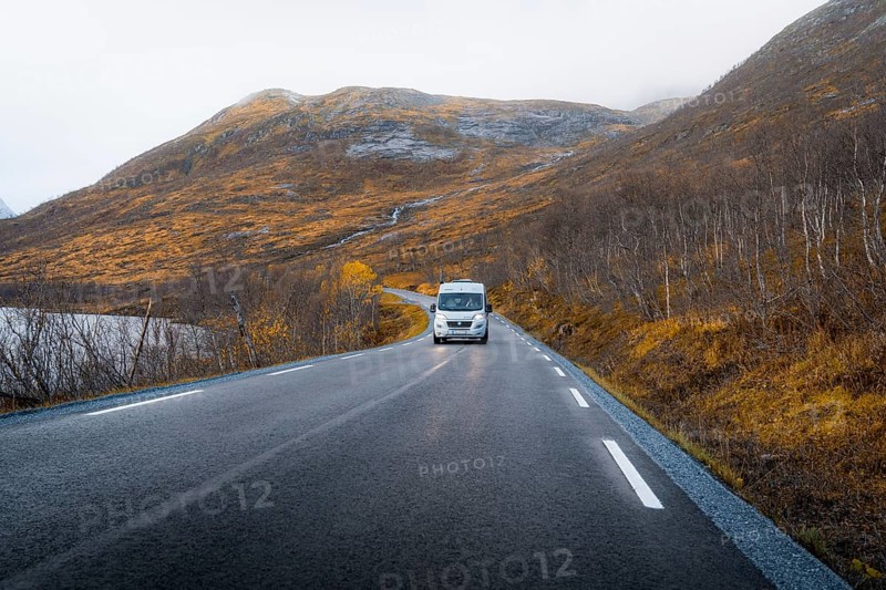 Campervan on a road with autumnal vegetation