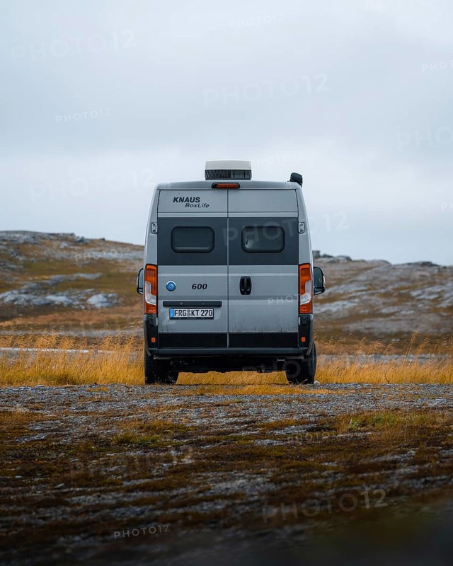 Campervan with rear view standing on parking lot near Kafjord