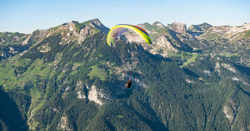 Paraglider in flight in front of the Rofan Mountains