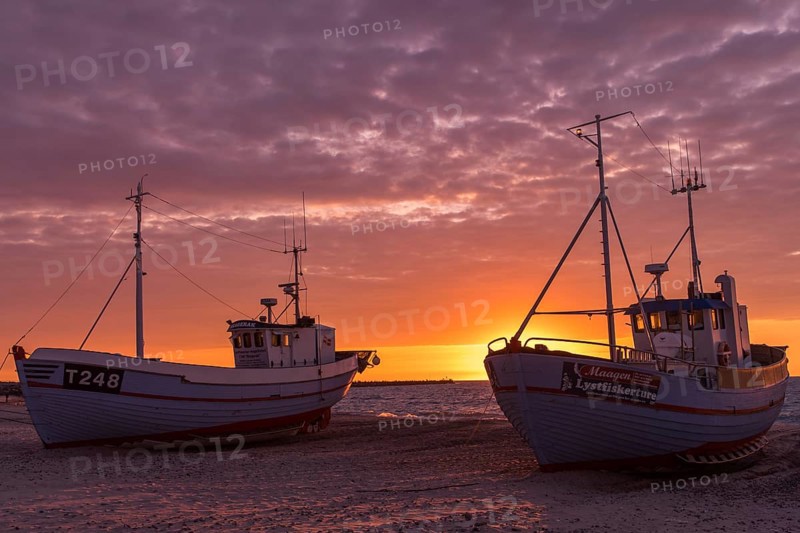Fishing boats on the beach at sunset