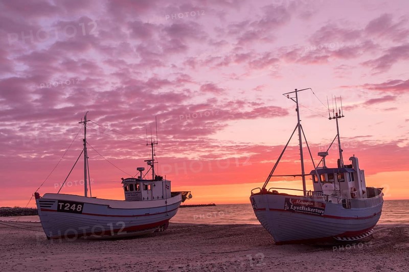 Fishing boats on the beach at sunset