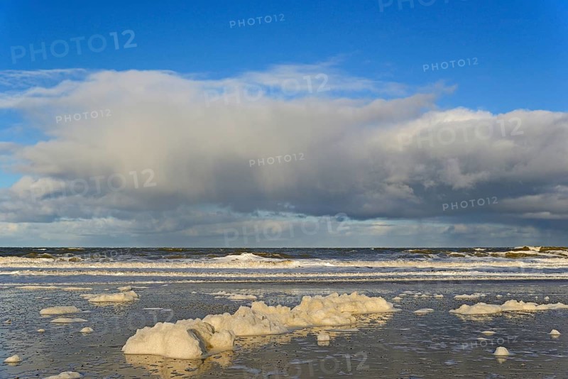 Waves on a sandy beach with foam formation