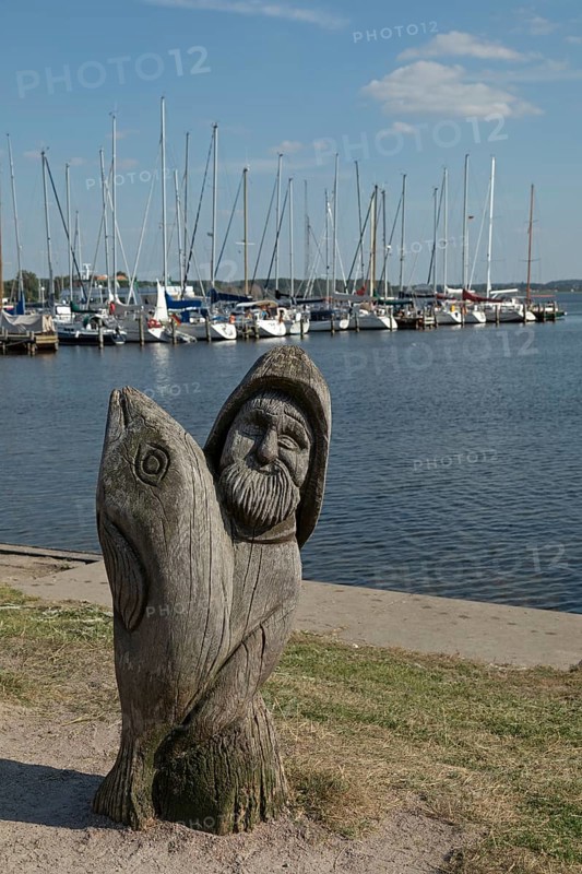 Wooden figure of a fisherman with fish at the marina