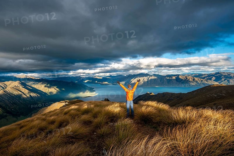 Hiker stretches his arms in the air