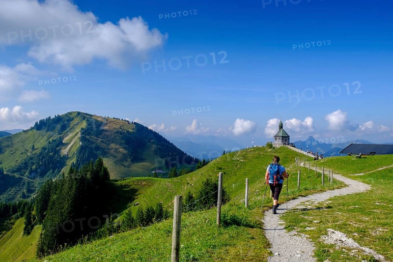 Hiker in front of the Wallberg church Heilig Kreuz