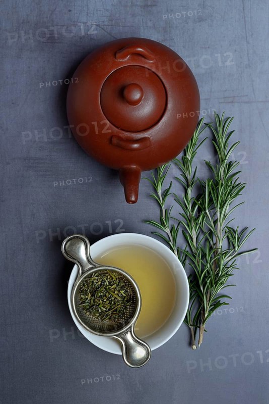 A cup of rosemary tea with tea strainer