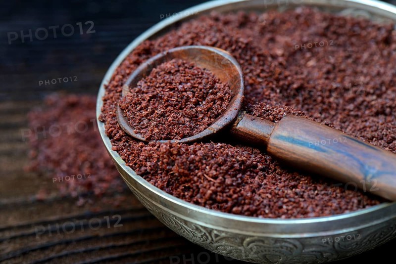 Sumac powder in bowl and spoon